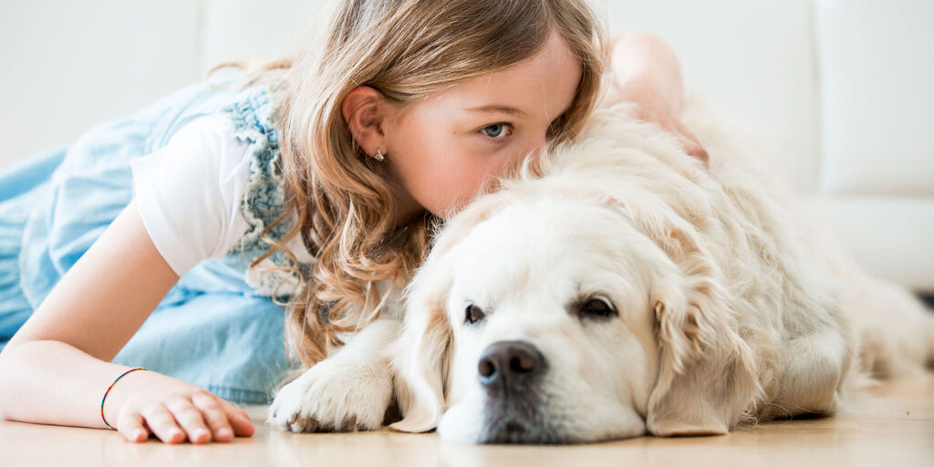 Ein Mädchen kuschelt mit ihrem Hund.